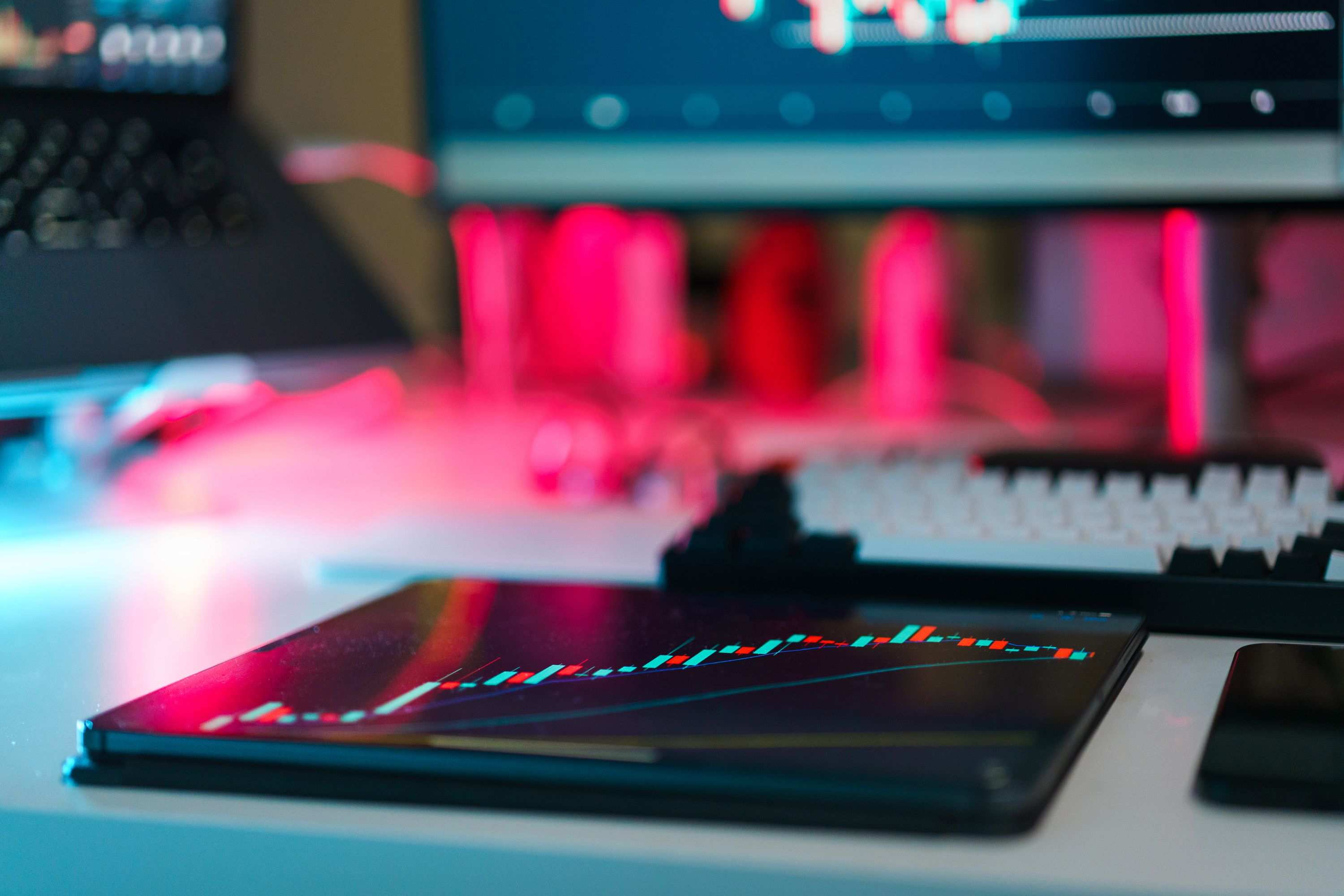 Breiter Schreibtisch mit Monitor, auf dem Tabellen und ein Liniendiagramm zu sehen sind — Charts auf Bildschirmen